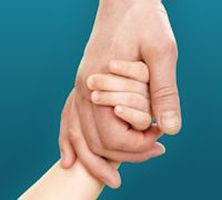 A child's hand holding an adult's hand.