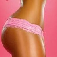 A side view photo of a woman's lower body in pink underwear.