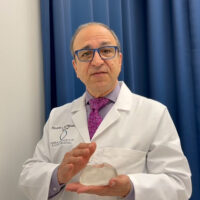 Dr. Rodriguez holding a breast implant as he explains capsular contractor reduction with motiva breast implants
