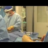 Several medical professionals at work in the operating room.